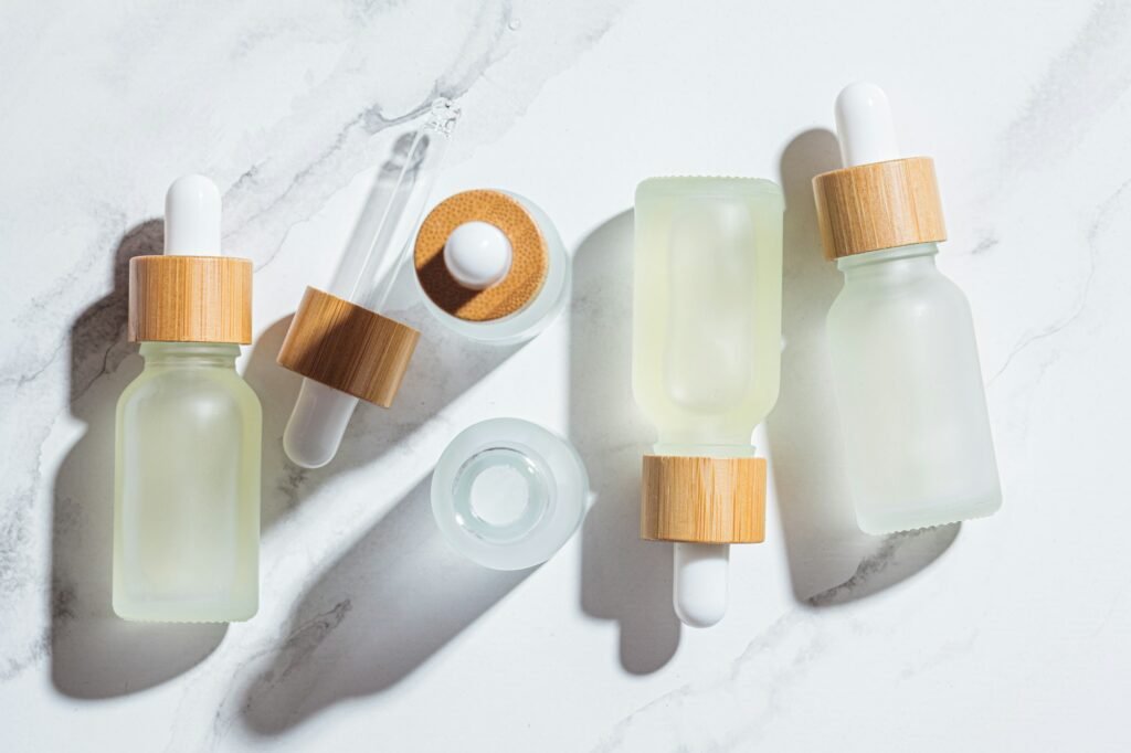 Essential oils in glass bottles, white marble background.