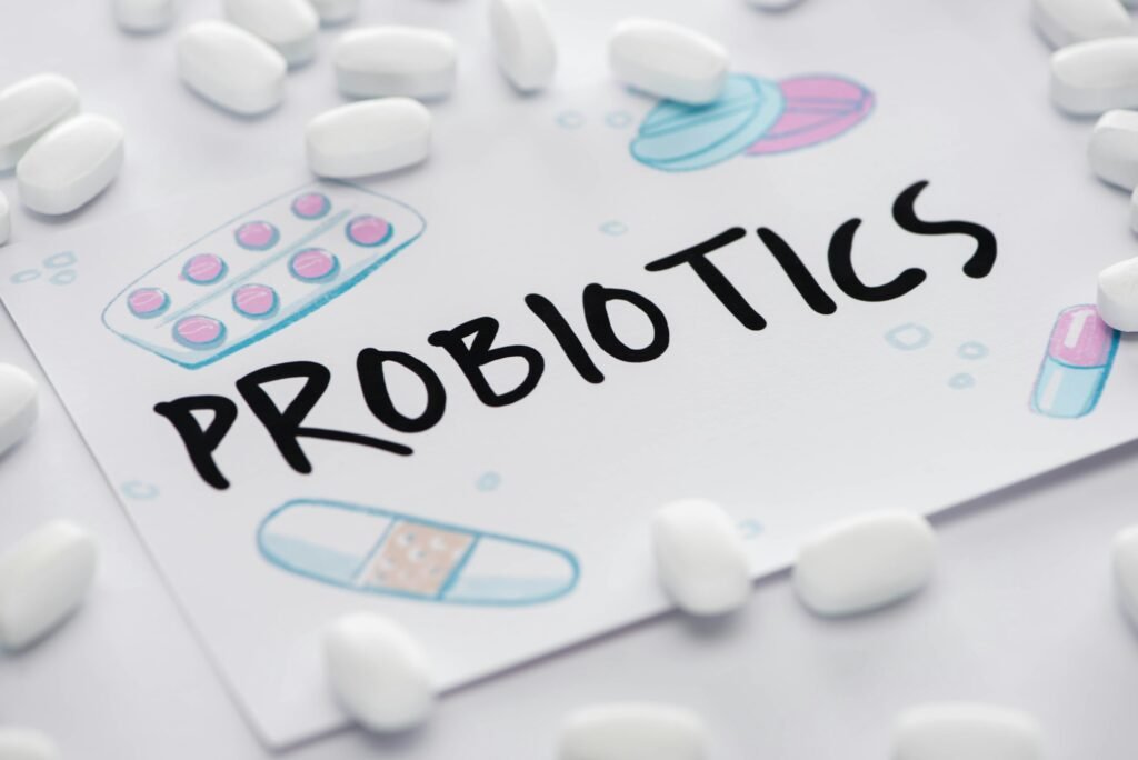 selective focus of drawing with probiotics lettering near pills on white background