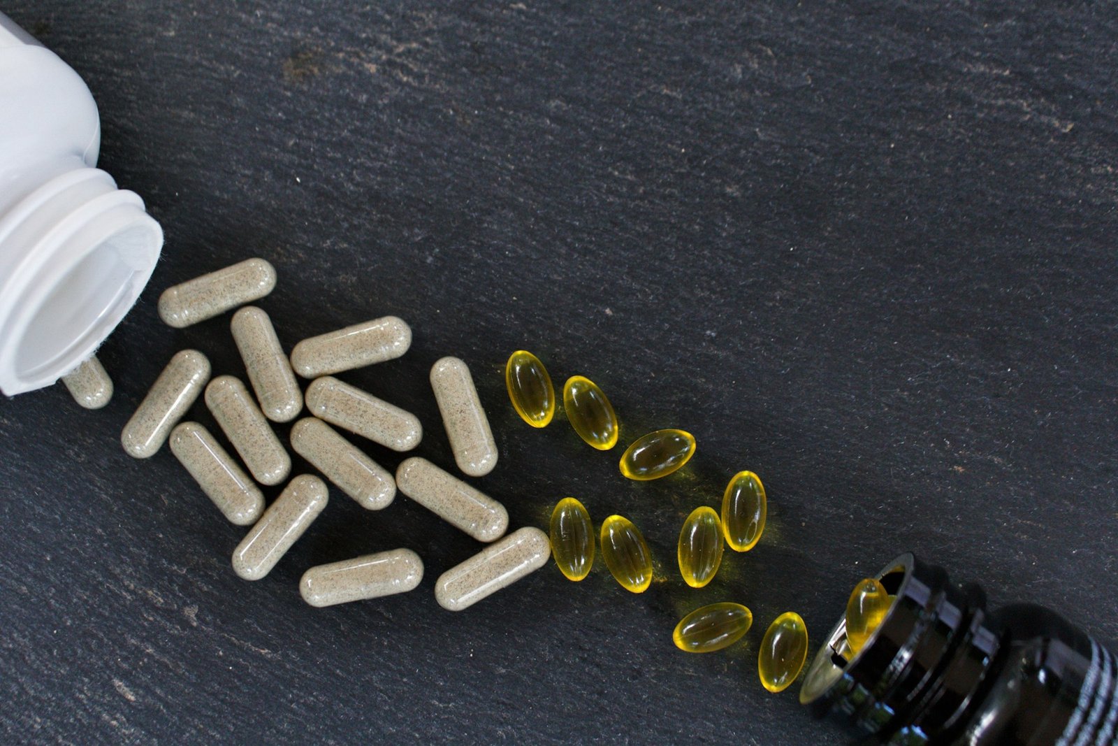 Top view of vitamin supplements on a black surface